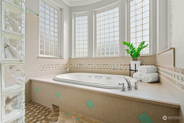 bathroom with plenty of natural light, ornamental molding, and tiled tub