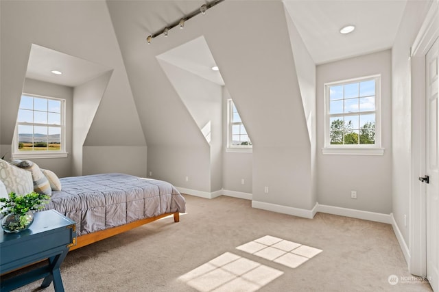 carpeted bedroom featuring multiple windows and vaulted ceiling