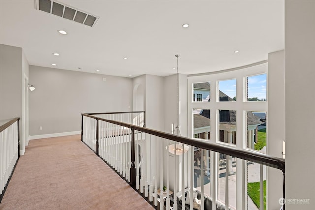 hallway featuring light colored carpet