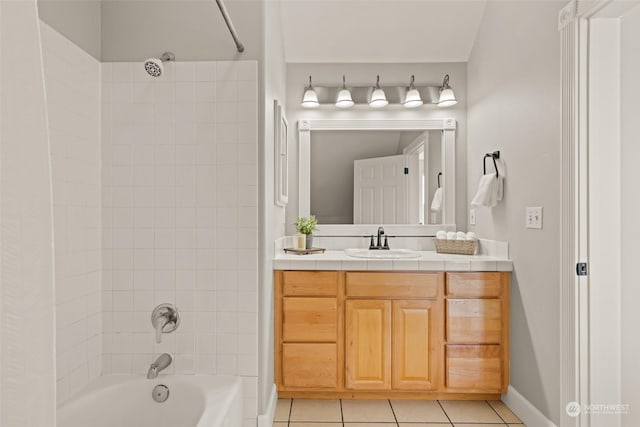 bathroom with tile patterned floors, vanity, and tiled shower / bath