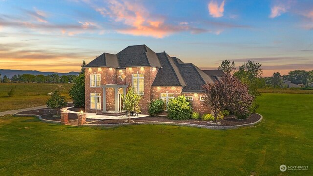 view of front of house featuring a lawn and a patio