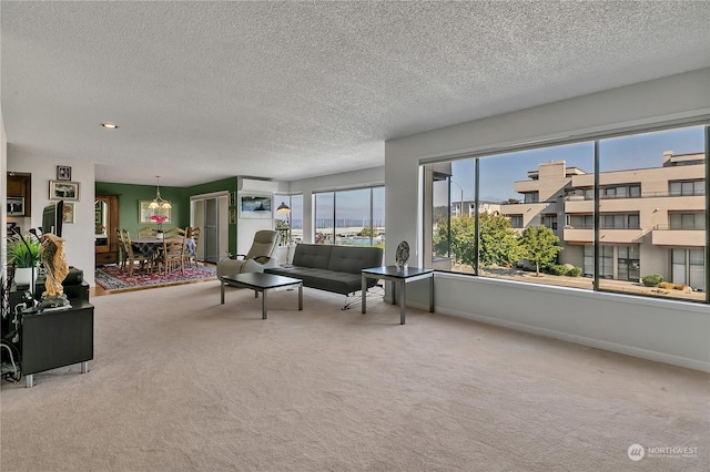 living room with a wall unit AC, a textured ceiling, and carpet flooring