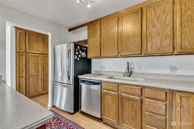 kitchen featuring stainless steel appliances, light hardwood / wood-style floors, and sink