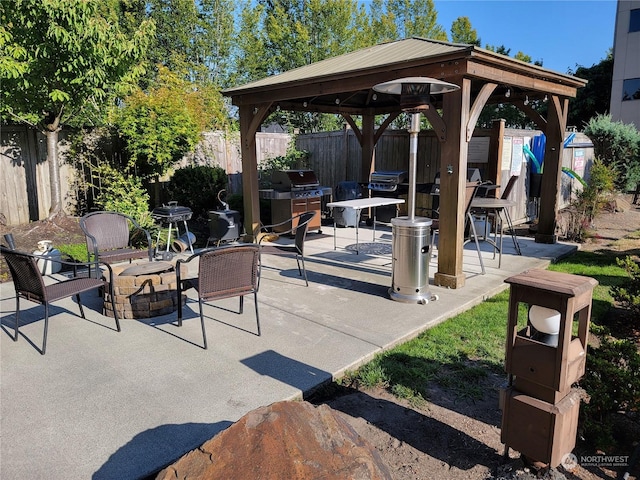 view of patio / terrace featuring a gazebo, area for grilling, and an outdoor fire pit