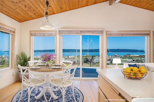 dining space with light hardwood / wood-style flooring, a water view, wood ceiling, and lofted ceiling