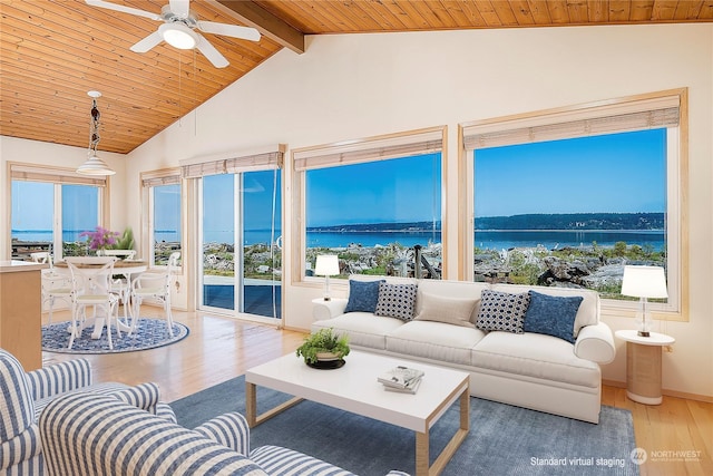 sunroom / solarium featuring beam ceiling and a water view