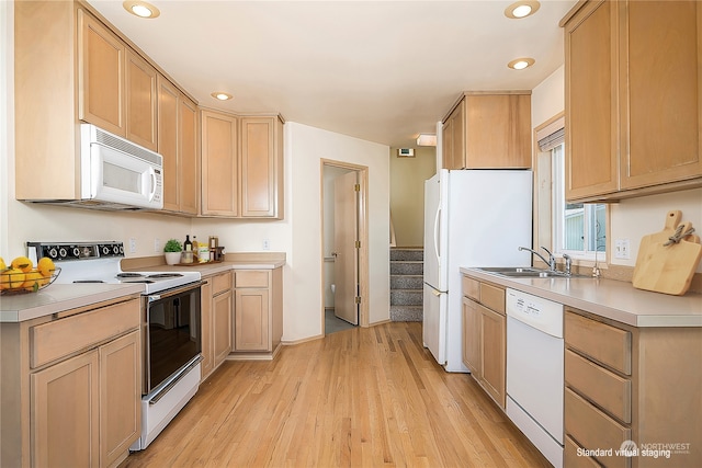 kitchen with sink, light wood-type flooring, light brown cabinetry, and white appliances