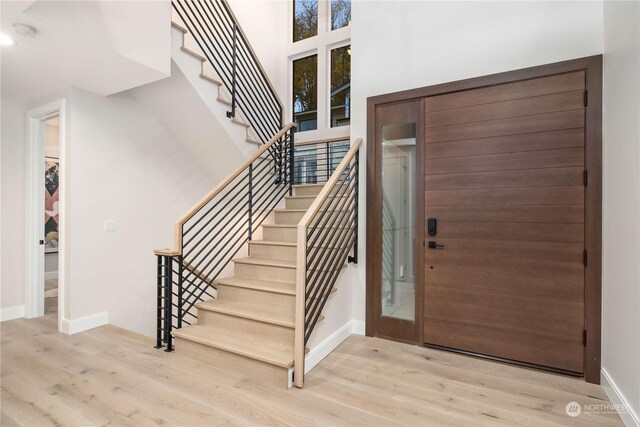 entryway featuring a high ceiling and light hardwood / wood-style floors