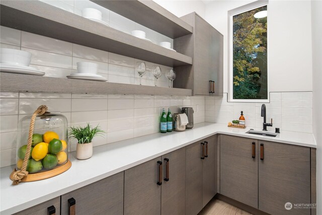 kitchen featuring backsplash, sink, and dark brown cabinetry