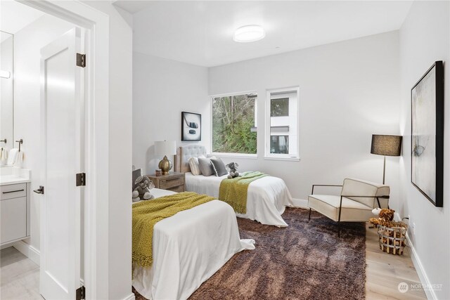 bedroom with light hardwood / wood-style flooring and connected bathroom