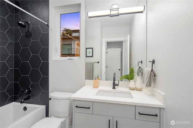 full bathroom featuring vanity, tiled shower / bath combo, and toilet