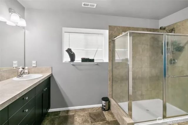 bathroom with walk in shower and vanity