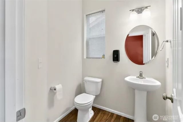 bathroom with hardwood / wood-style flooring and toilet