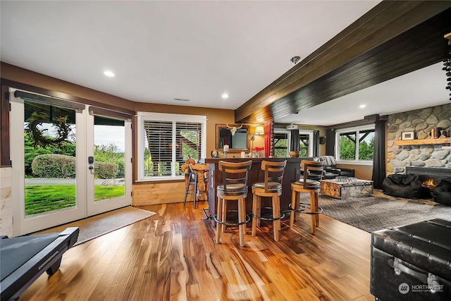 interior space with french doors, visible vents, light wood-style flooring, and a bar