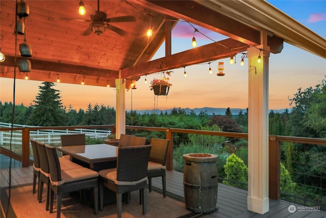 deck featuring outdoor dining area, a ceiling fan, and a gazebo