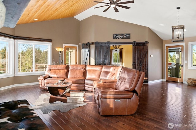 living area with a barn door, baseboards, ceiling fan, wood finished floors, and high vaulted ceiling