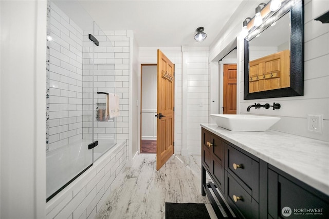 full bathroom with tiled shower / bath, wood finished floors, and vanity