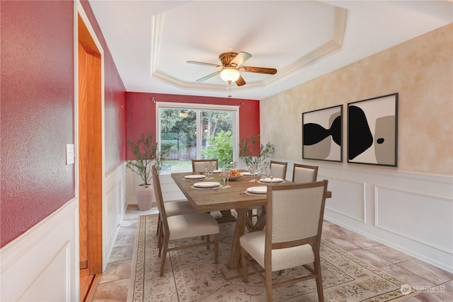 dining area featuring ceiling fan and a tray ceiling