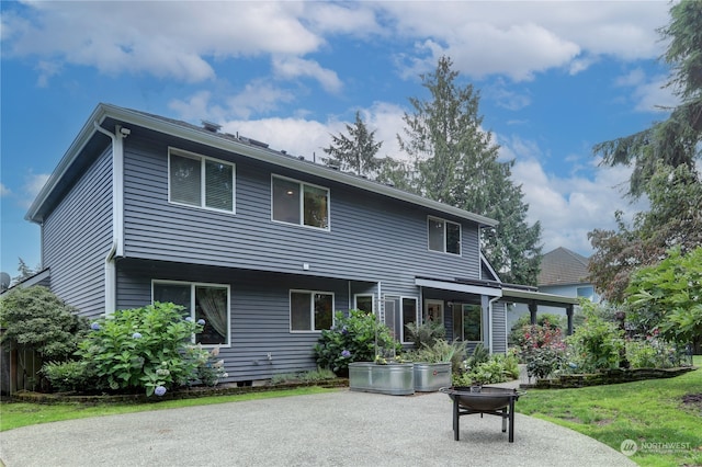 back of property with a patio area and a yard