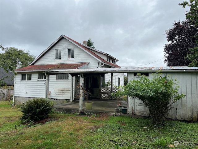 rear view of house with a lawn and a patio area