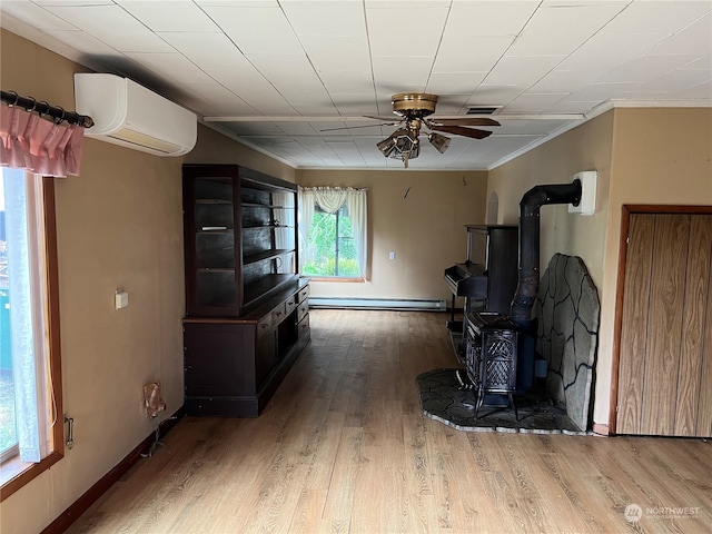 misc room featuring a baseboard radiator, a wall unit AC, hardwood / wood-style floors, and a wood stove