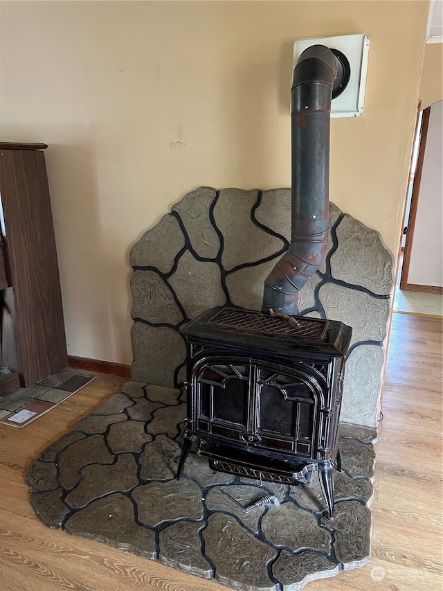 details with a wood stove and wood-type flooring