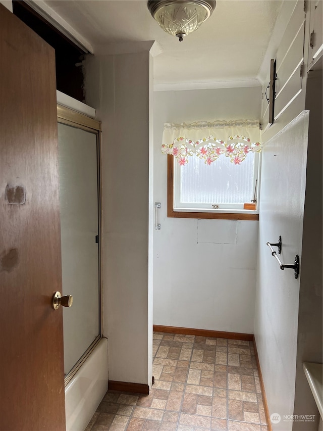 bathroom featuring combined bath / shower with glass door, tile patterned floors, and ornamental molding