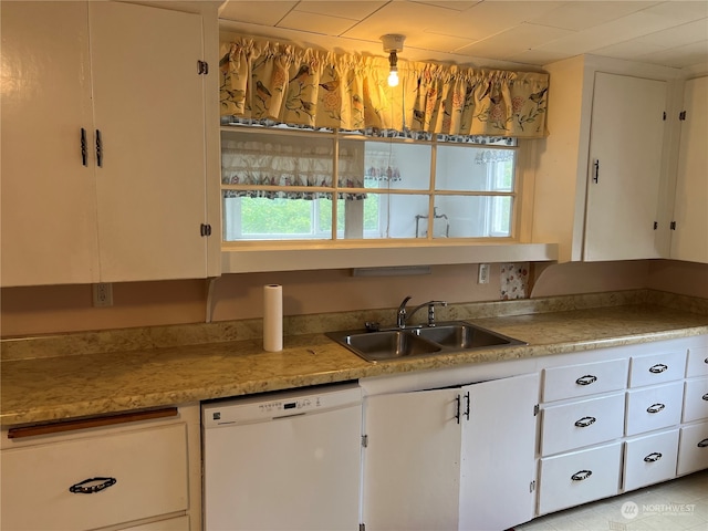 kitchen with sink, white dishwasher, and white cabinets