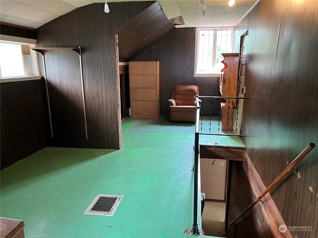 additional living space featuring wood walls and lofted ceiling