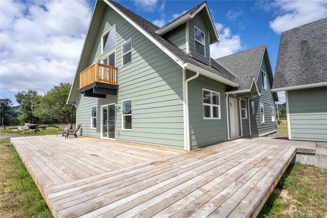 rear view of house featuring a wooden deck