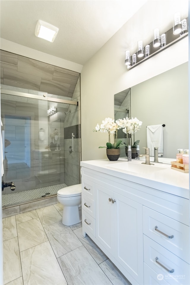 bathroom featuring a shower with shower door, toilet, tile patterned flooring, and vanity