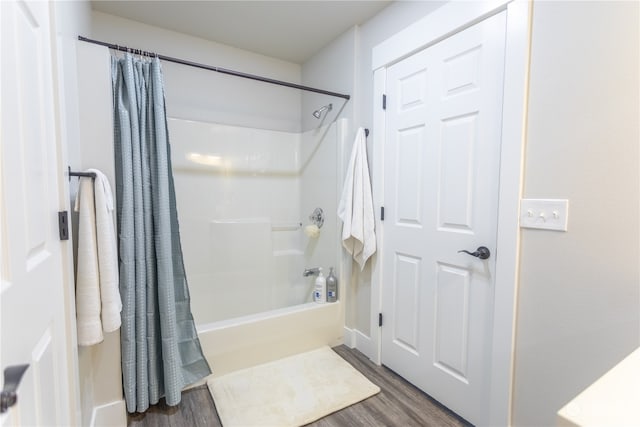 bathroom with hardwood / wood-style flooring and shower / bath combo