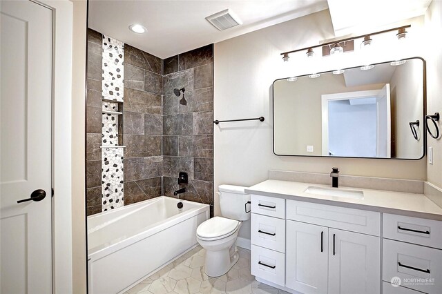 full bathroom featuring toilet, tiled shower / bath, vanity, and tile patterned floors