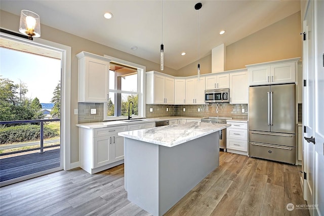 kitchen featuring a center island, sink, high quality appliances, and white cabinets