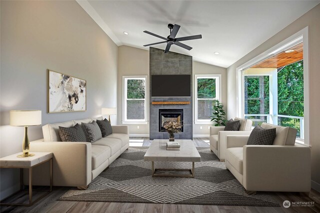 living room with hardwood / wood-style floors, vaulted ceiling, ceiling fan, and a fireplace