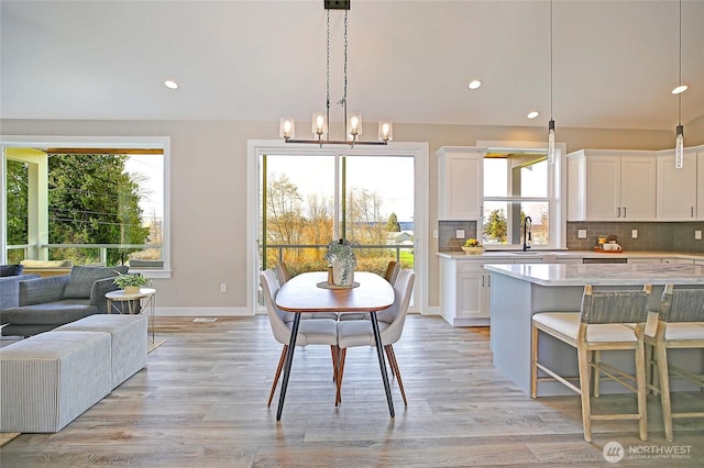 dining area featuring an inviting chandelier, recessed lighting, baseboards, and light wood finished floors