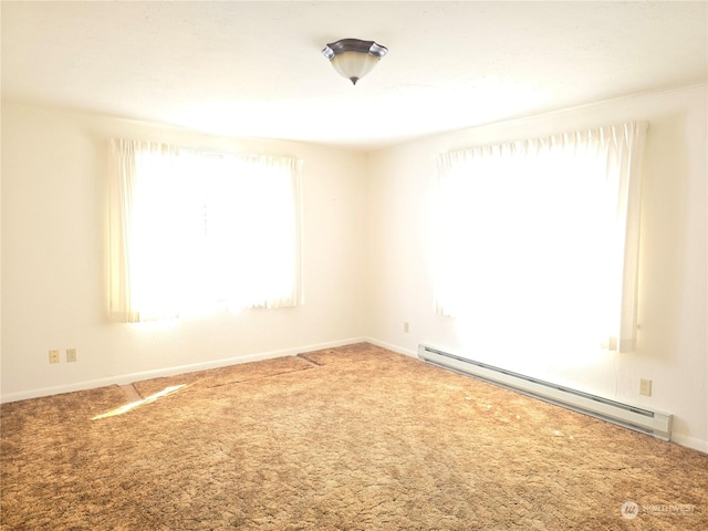 carpeted spare room featuring baseboards and baseboard heating