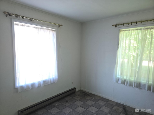 spare room with a healthy amount of sunlight, crown molding, and baseboard heating