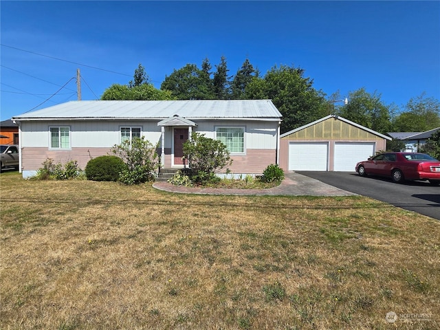 single story home featuring an outbuilding, metal roof, a front yard, and a garage