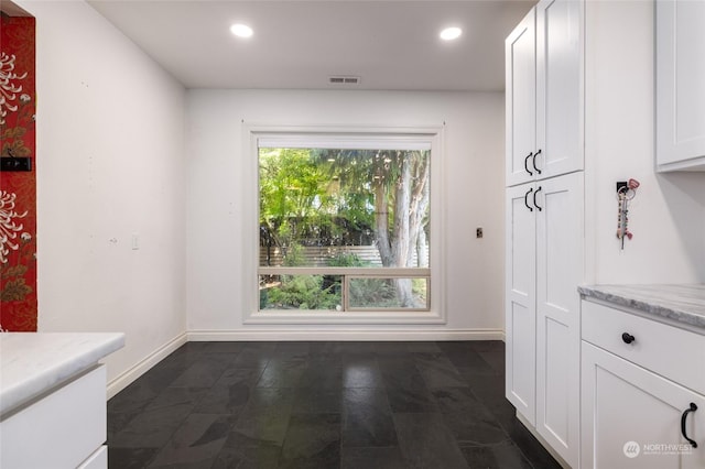 unfurnished dining area featuring baseboards, visible vents, and recessed lighting