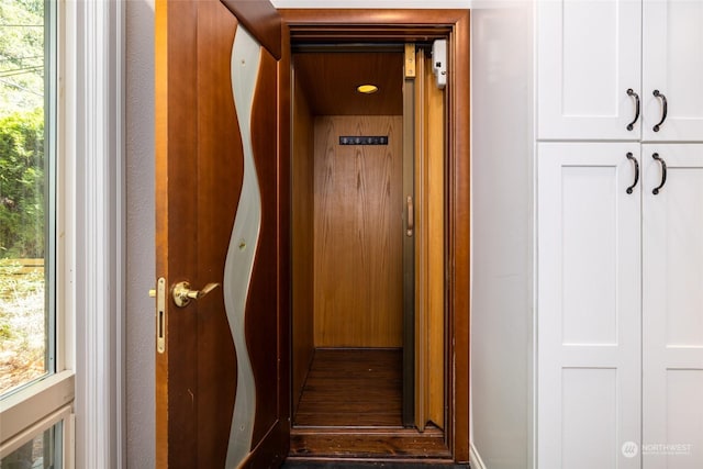 hallway with elevator and plenty of natural light