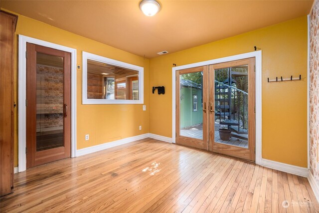 unfurnished room featuring light hardwood / wood-style floors and french doors