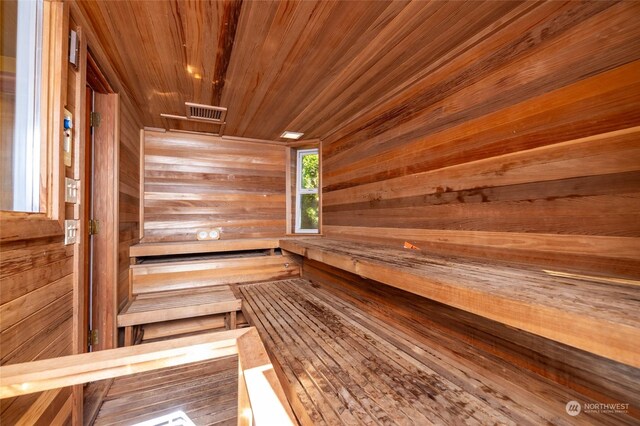 view of sauna / steam room with wooden ceiling and wooden walls