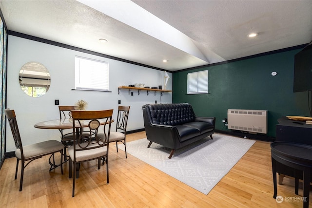 living room with recessed lighting, light wood-style flooring, heating unit, and a textured ceiling