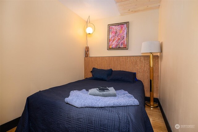 bedroom featuring lofted ceiling and light wood-type flooring