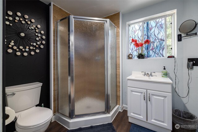 bathroom featuring hardwood / wood-style flooring, toilet, an enclosed shower, and vanity