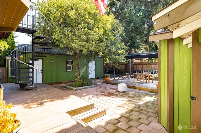 view of patio / terrace featuring fence, stairway, and an outdoor structure