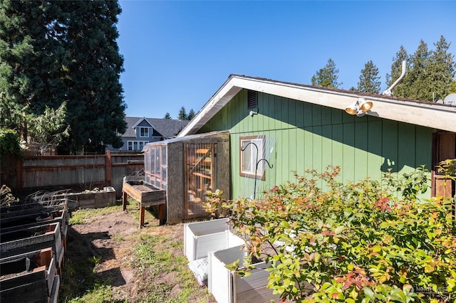 view of outdoor structure with a vegetable garden and fence