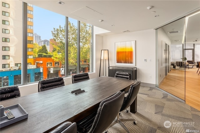 office space with floor to ceiling windows and light hardwood / wood-style floors