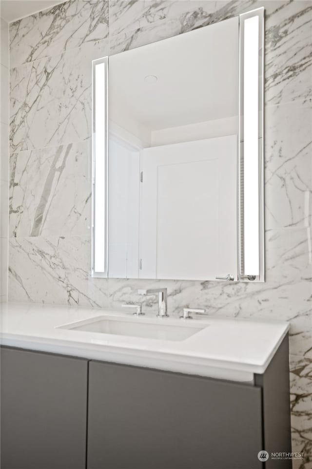 bathroom with vanity and tile walls